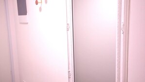 Eine Tür mit Lichtschalter und einem kleinen, rechteckigen Gegenstand an der Wand.