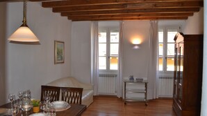 Een eetgedeelte met een tafel voor vier personen, een bank, een radiator en een kast.
