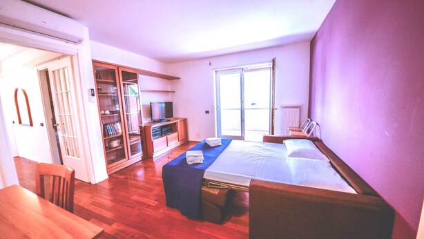 Une chambre à coucher comprenant un lit, un bureau, une télévision et une armoire.