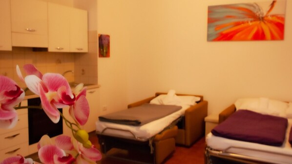 Una habitación con cama, una mesita, una silla y un armario.
