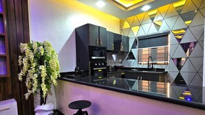 Una cocina moderna con armarios oscuros, encimera negra y salpicadero geométrico.