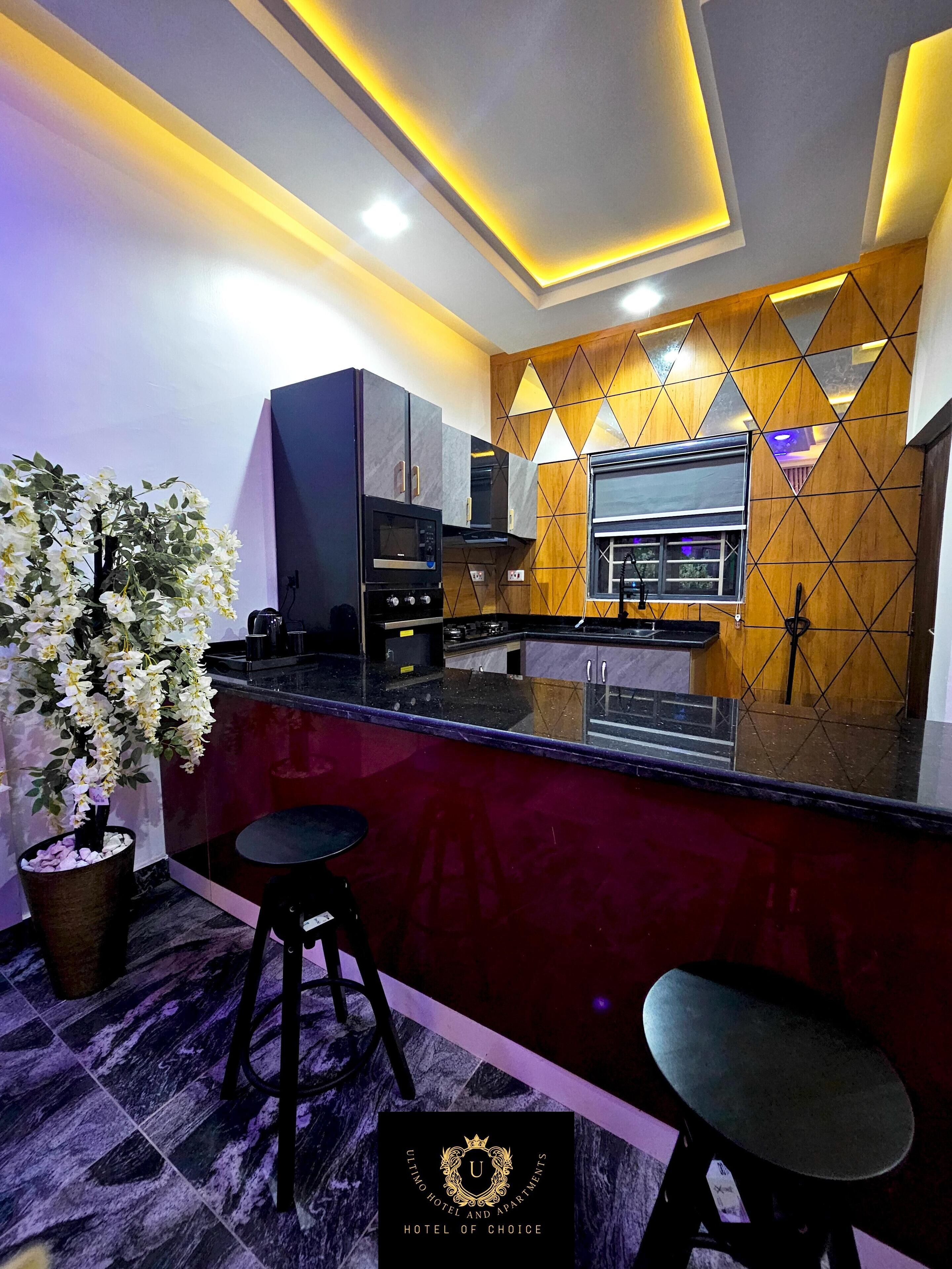 Una cucina moderna con un piano di lavoro in marmo, elettrodomestici integrati e un pannello decorativo a parete.