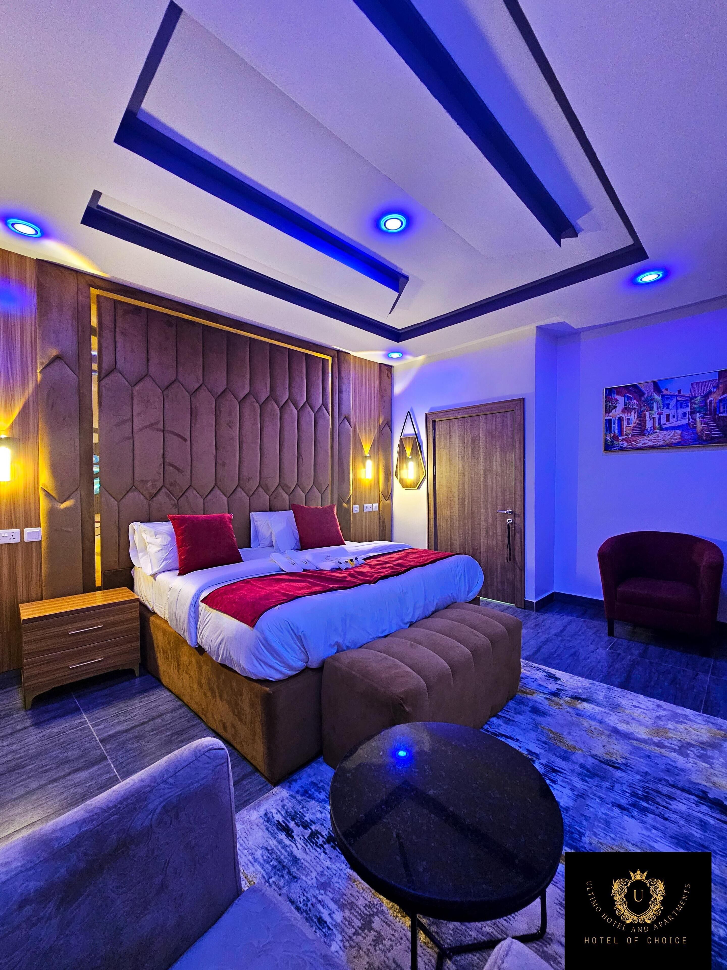 Une chambre moderne avec un grand lit, des tables de chevet, un canapé et une petite table.