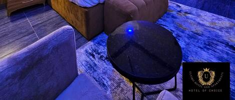 Une chambre moderne avec un grand lit, des tables de chevet, un canapé et une petite table.