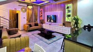 Una sala de estar moderna con sofá, televisión y plantas decorativas.