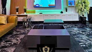 Un hall d’hôtel moderne doté d’un téléviseur à écran plat, d’un canapé, d’une table basse et d’une plante décorative.