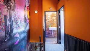 A hallway with a mural, a radiator, and a door leading to a room. - Terrace View · City Centre Modern Apartment (West Yorkshire)