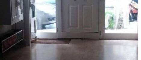 A room with a large sliding glass door leading to a parking area.