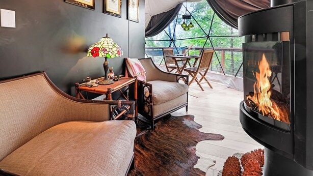 Una habitación acogedora con sofá, una mesa con lámpara y chimenea.