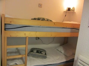 A bunk bed with a ladder, a pillow, and a wall socket. - 2nd floor, view mountain, balcony, parking, tv, ski locker, 23m², Les Contamines-Montjoie (Les Contamines-Montjoie)