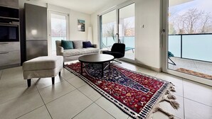 Een moderne woonkamer met een bank, salontafel en een kamerkleed met dessin.