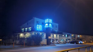 A modern building with illuminated signage for 'hira' and 'Marriott'. - Hira Boarding Aparthotel (Dingolfing)