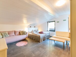 Une pièce comprenant un lit, un canapé, une petite table et une fenêtre.