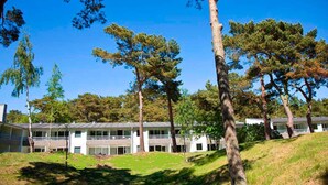 En byggnad med många fönster och en gräsyta framför.