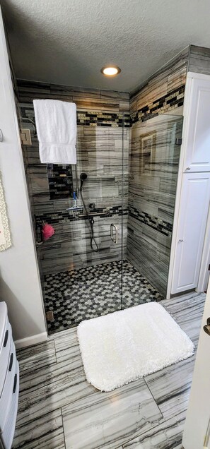 Shower, jetted tub, towels, toilet paper