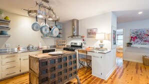 Una cocina moderna con armarios de madera, una isla central y un colgador para ollas.
