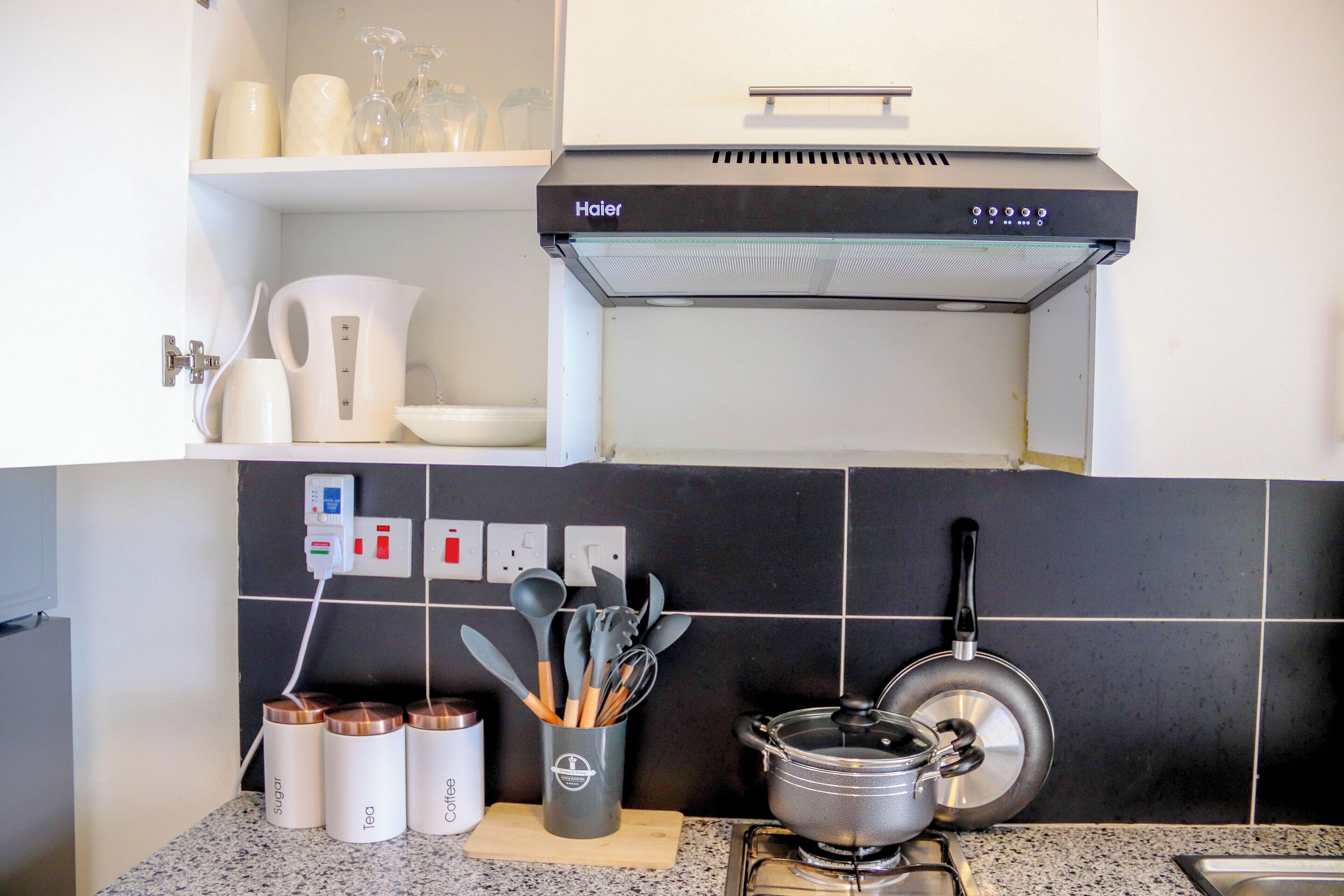 Eine Küche mit Herd, Töpfen, Wasserkocher und Kaffeemaschine.