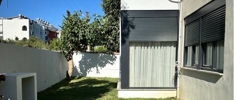 A modern building with a large window and a closed roller shutter.