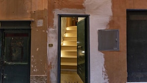 Un couloir étroit avec un escalier menant à une pièce.
