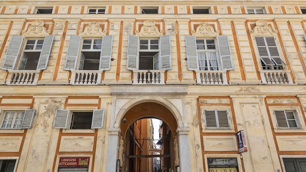 Un bâtiment historique doté de détails architecturaux raffinés, notamment une arche centrale et de nombreux balcons.