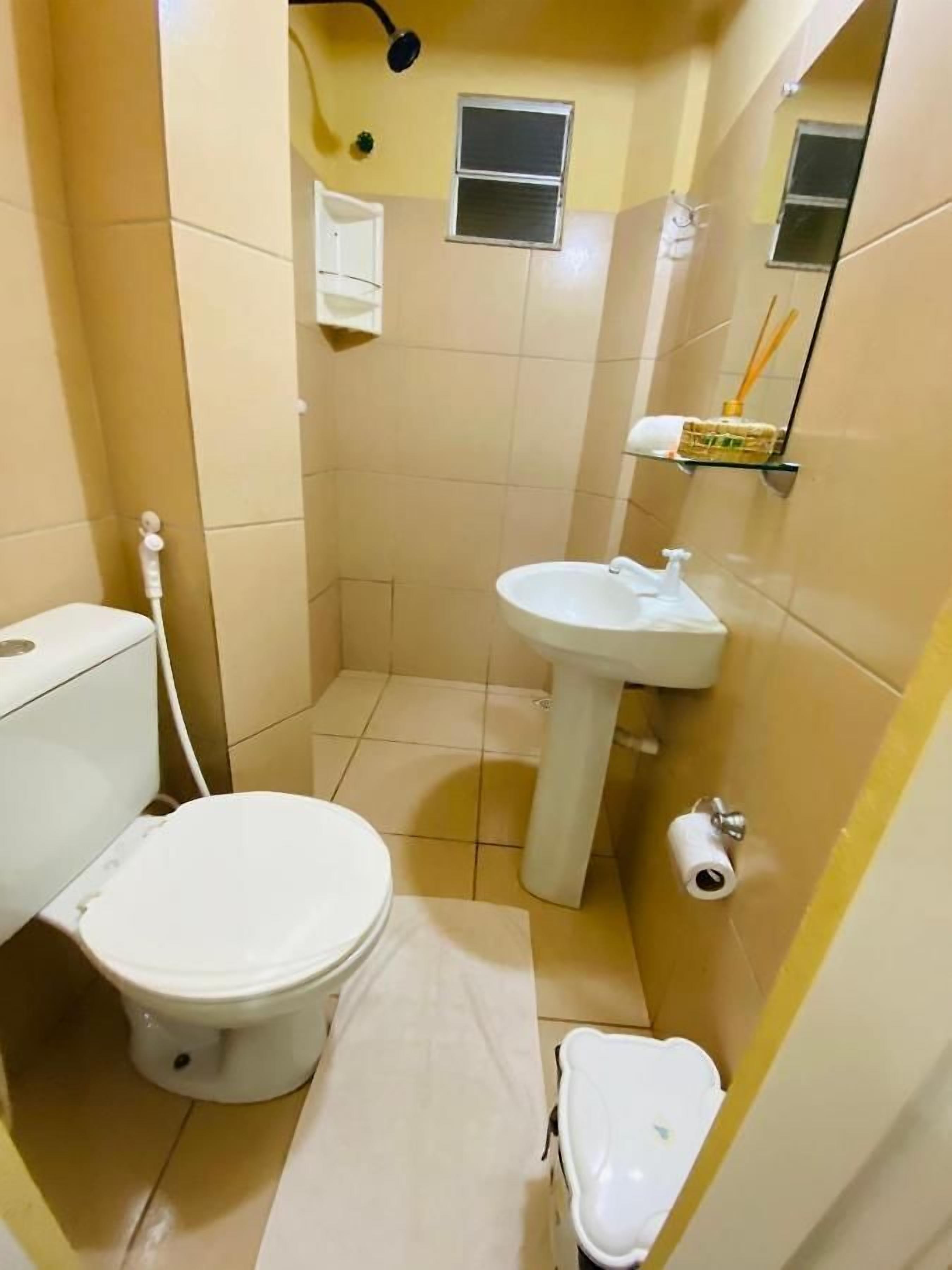 A small bathroom with a toilet, sink, and a small window.