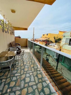 A balcony with a tiled floor, metal chairs, a table, and a railing. - Pousada Terral (Aracati)