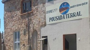 Un bâtiment doté d’une façade en pierre et d’une enseigne indiquant « POUSADA TERRAL », ainsi qu’une adresse électronique pour prendre contact.
