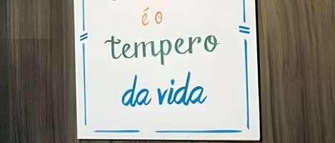 Un cartello con la scritta 'AMOR é o tempero da vida' su sfondo di legno.
