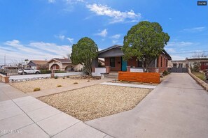 Il s’agit d’une propriété résidentielle dotée d’une allée pavée, d’un jardin aménagé avec du gravier et de petites plantes, et d’une maison à deux étages au design moderne.