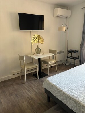 Relax in a stylish room with a flat-screen TV, comfortable seating area, and a cozy bed.