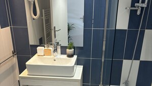 A modern bathroom with a white sink, mirror, and shower. - Studio 1 room + pools  (Arles)