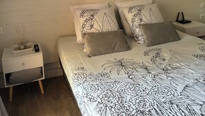 A bedroom with a bed, nightstands, and wall art. - Studio 1 room + pools  (Arles)
