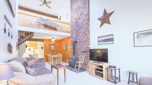 Un espacio habitable en varios niveles, con chimenea, televisor y zona de estar.