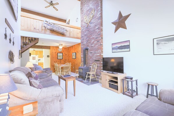 Un espacio habitable en varios niveles, con chimenea, televisor y zona de estar.
