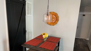 Un comedor con una mesa, sillas y un adorno de pared.