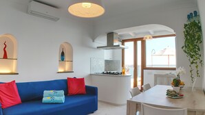 A modern kitchen with a gas stove, white cabinets, and a view to the outside.