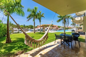 Una hamaca, asientos exteriores y vistas a una piscina y barcos.