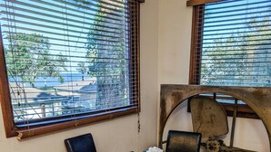 A dining area with a round wooden table, four chairs, and a woven rug. - Perfect Family Escape: Playground, Fire Pit, Games & Boat Parking Near Kemah! (Bacliff)