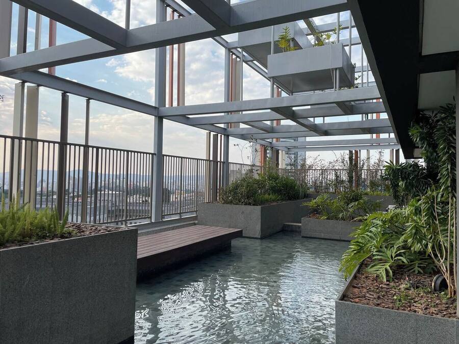 Uma cascata interior com vasos de plantas e vista para a cidade.
