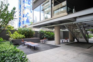 An outdoor terrace with seating, greenery, and a staircase leading to an upper level. - On Melo Alves R (São Paulo)