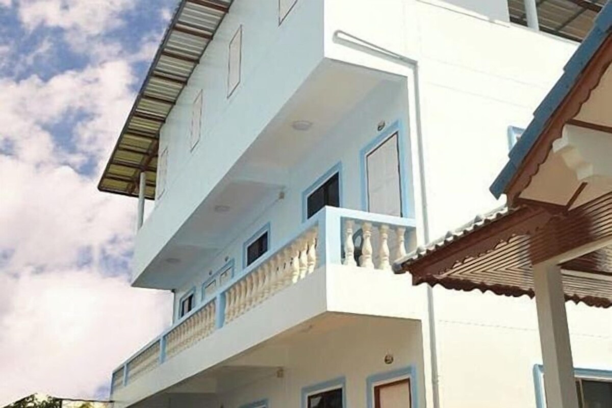 A multi-story building with balconies, a flat roof, and a clear sky.