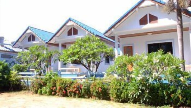 A row of white buildings with blue roofs, surrounded by greenery. - Pama Resort (Rayong City)