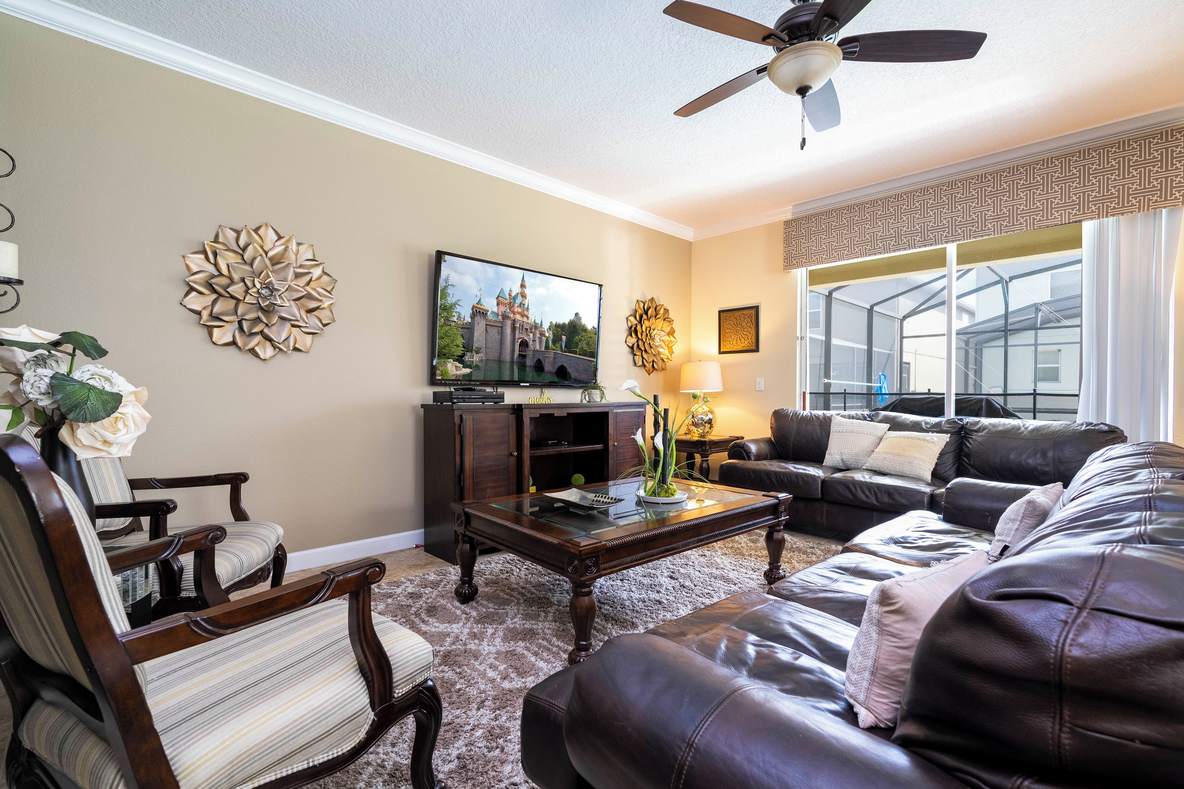 A living room with a sofa, armchair, coffee table, and a TV on a stand.