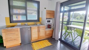 A compact kitchen with wooden cabinets, a built-in microwave, and a sink.