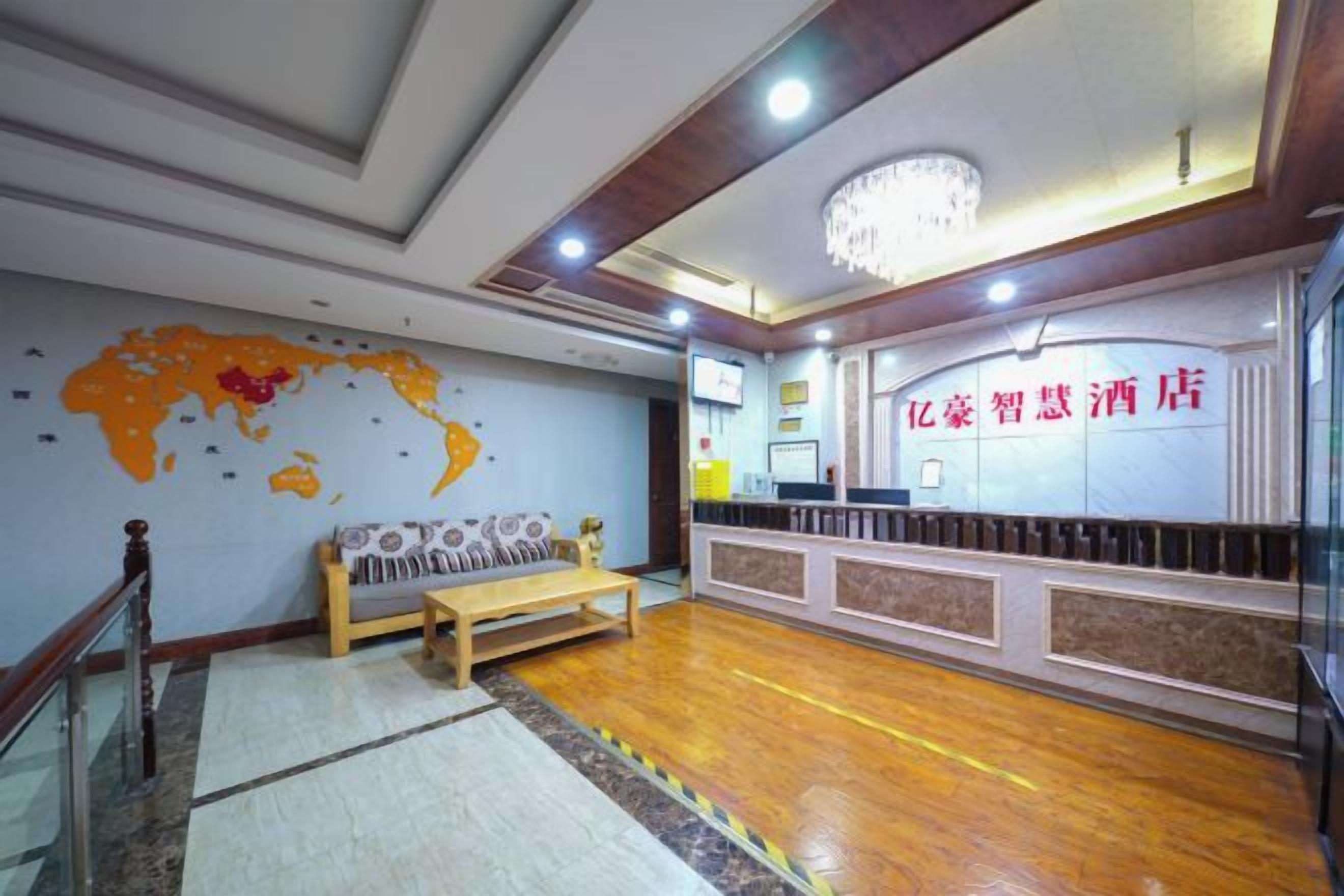 Um saguão de hotel com balcão de recepção, um sofá e um mapa-múndi na parede.