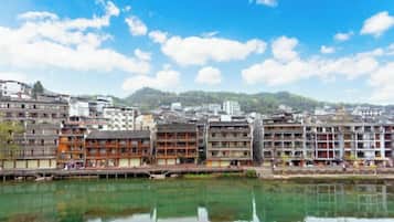 Vista del río con edificios tradicionales de varios pisos, reflejándose en el agua.