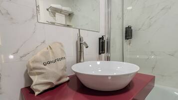 A bathroom with a white marble sink, a towel, and a shower.