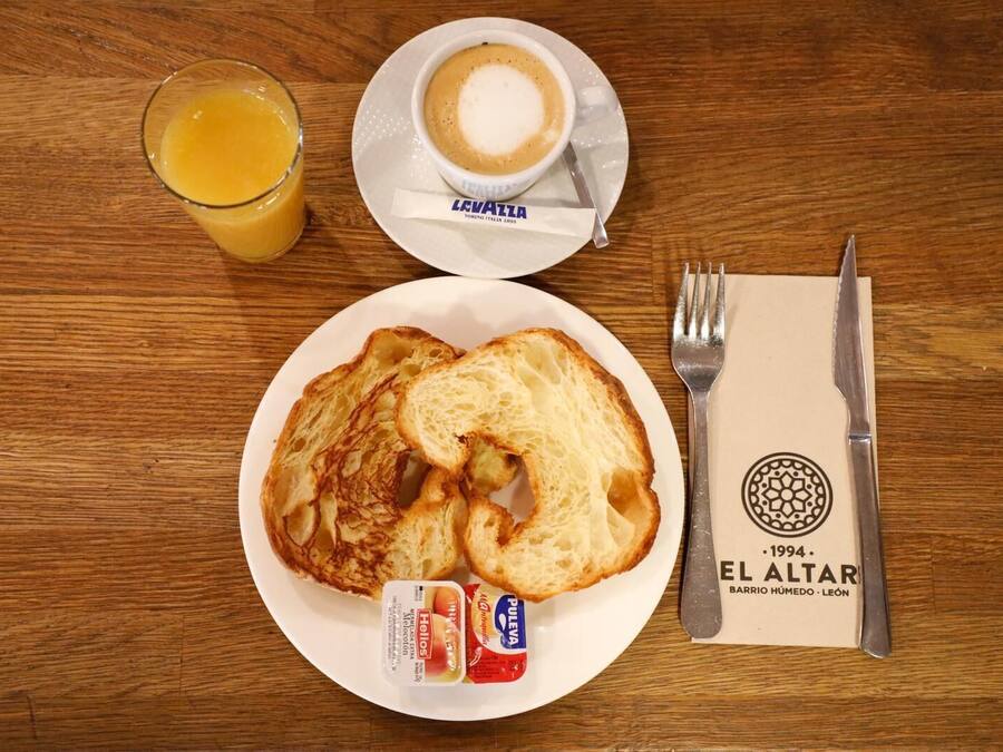 A breakfast plate with toast, a glass of orange juice, and a cup of coffee on a wooden table.