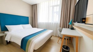 A hotel room with a bed, a desk, a chair, a TV, and a window with curtains. - Home Inn Business Hotel (Benxi Railway Station Branch) (Benxi)