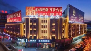 A hotel with a prominent sign in the center, multiple smaller signs on the facade, and a large illuminated sign above the entrance. - Home Inn Business Hotel (Benxi Railway Station Branch) (Benxi)